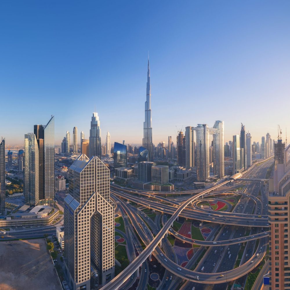 Aerial view of Dubai Downtown skyline, highway roads or street in United Arab Emirates or UAE. Financial district and business area in smart urban city. Skyscraper and high-rise buildings at sunset.