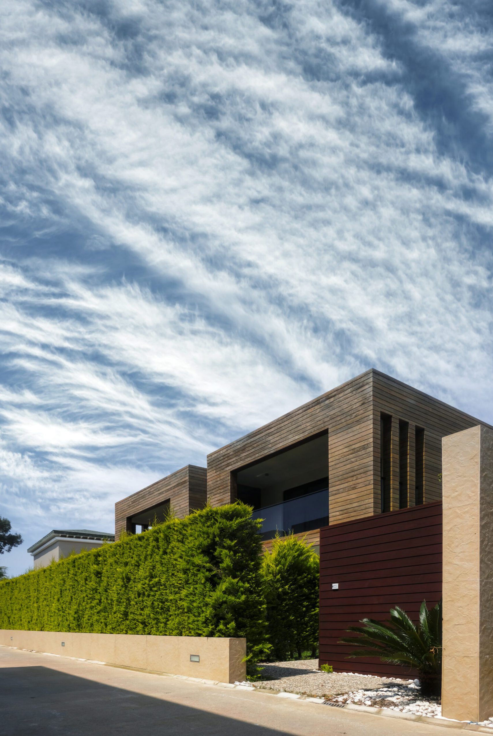 Modern houses with green plant wall on blue sky background. Actual eco architecture. Real estate concept
