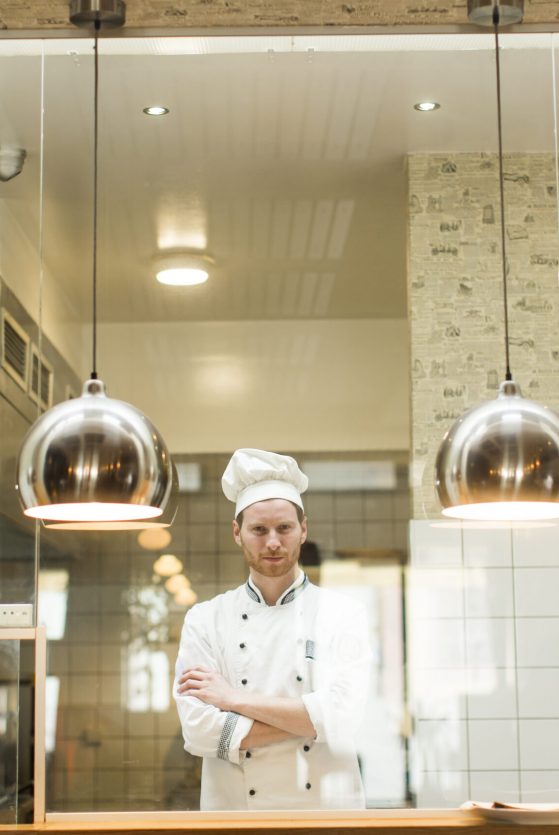 Portrait of smiling young chef in the kitchen